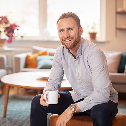 Mathias Deltner legitimerad Naprapat på Smood Malmö City sitter på en stol med en kaffekopp i handen