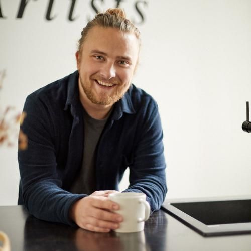 Olof Lancing legitimerad naprapat på Smood Malmö dricker kaffe vid ett skrivbord